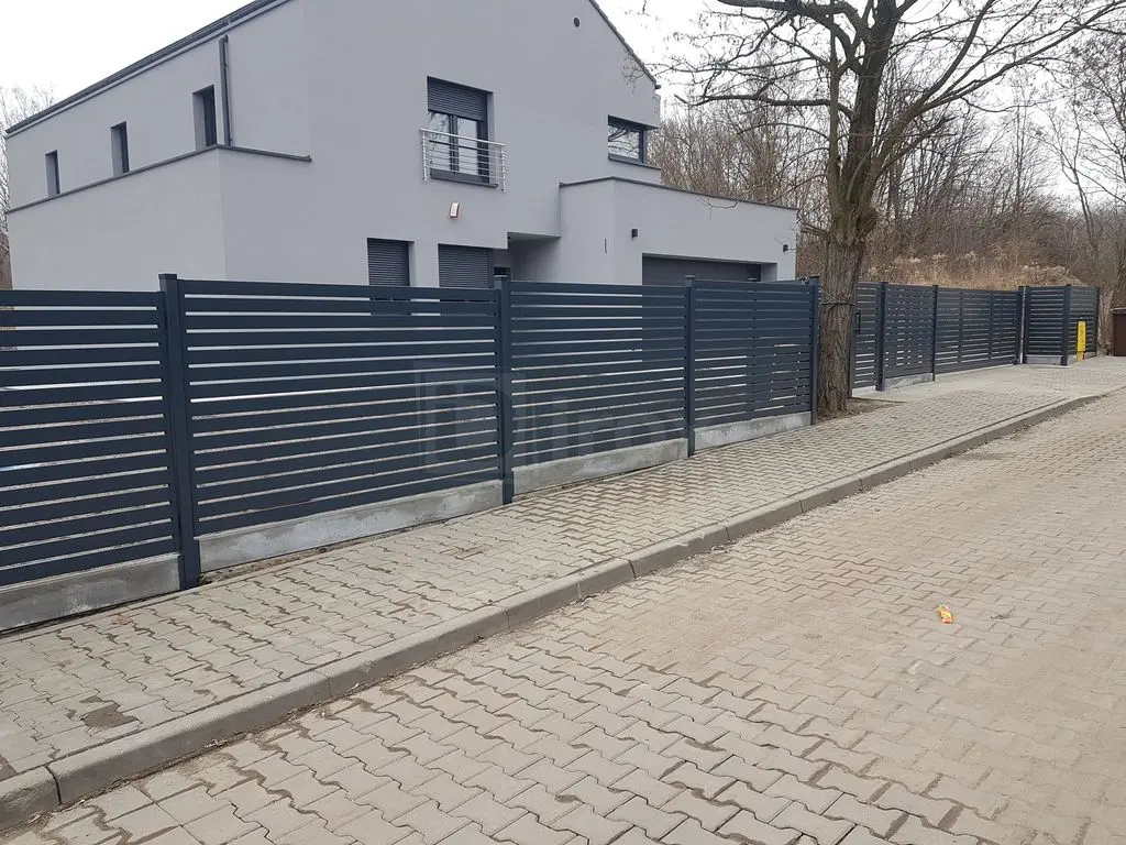 Nowoczesne ogrodzenie grafitowe od strony chodnika publicznego
